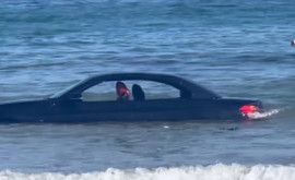 O mașină a ajuns în larg după ce șoferul a parcato pe plajă