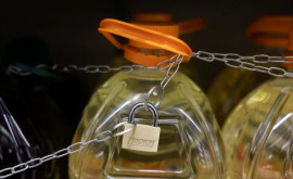 Bidoanele cu ulei de măsline legate cu lanțuri în magazinele din Spania