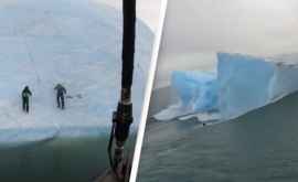 Un aisberg sa răsturnat în mare cu doi exploratori care încercau să îl escaladeze